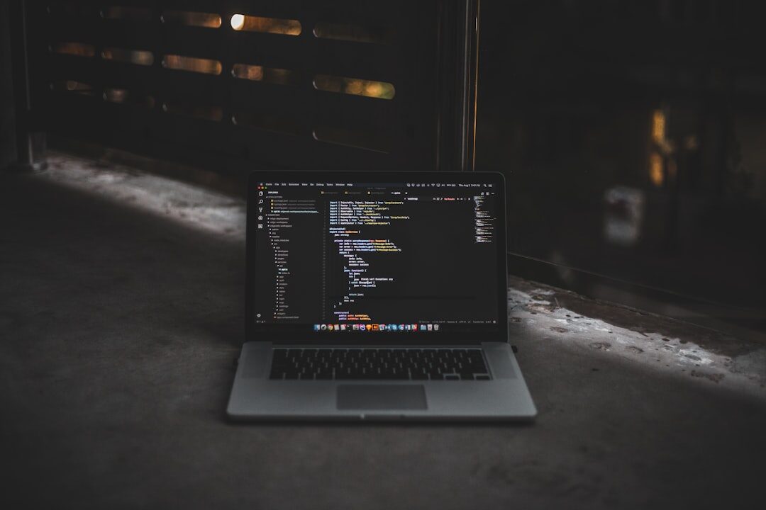 MacBook laptop displaying code on desk with coffee
