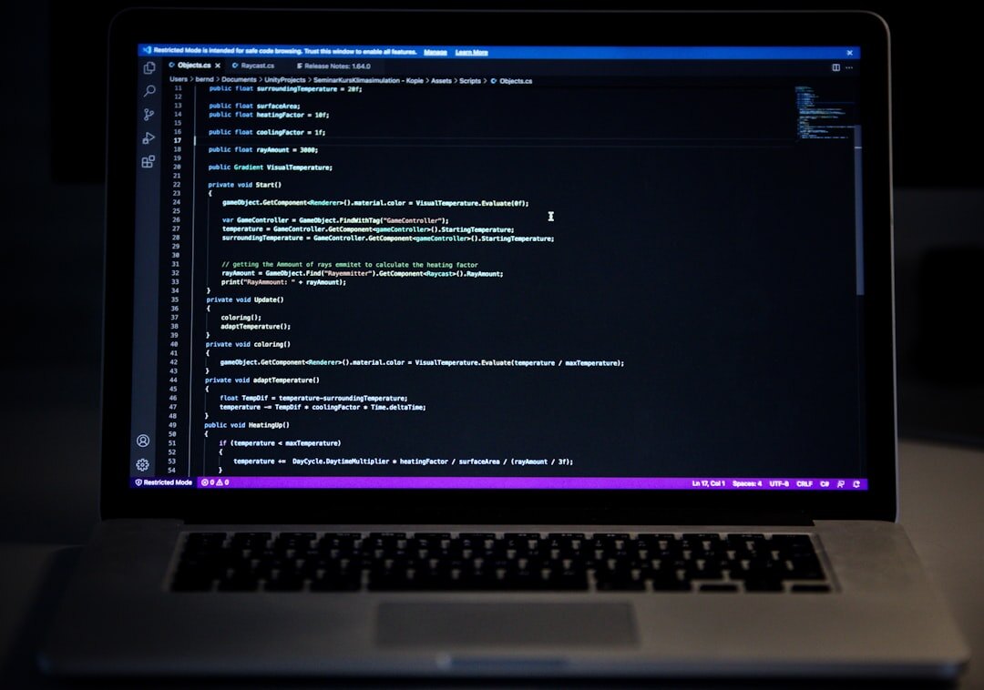 Laptop screen glowing in dark environment showing code and digital data